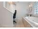 Bright bathroom with a built-in desk, jacuzzi tub, tile flooring, and a vanity with a sink and mirror at 32060A Flint Ridge Rd, Albemarle, NC 28001