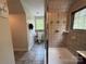 Tiled bathroom featuring a tiled shower, toilet, and a window offering natural light at 32060A Flint Ridge Rd, Albemarle, NC 28001