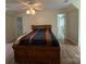 Spacious bedroom featuring wood flooring, a ceiling fan, and a large bed with a blue and brown striped comforter at 32060A Flint Ridge Rd, Albemarle, NC 28001