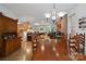 Spacious dining room with a view of the living area, brick fireplace, hardwood floors, and elegant chandelier at 32060A Flint Ridge Rd, Albemarle, NC 28001