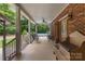 Inviting covered porch with seating area, brick accents, and a view of the refreshing pool at 32060A Flint Ridge Rd, Albemarle, NC 28001