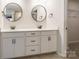 Bathroom with a white double sink vanity, bronze fixtures, and round mirrors at 3832 Amalia Pl, Indian Land, SC 29707