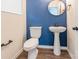 Bathroom featuring a pedestal sink, toilet, modern fixtures, blue accent wall, and neutral flooring at 3832 Amalia Pl, Indian Land, SC 29707