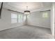 Spacious bedroom with plush carpet, a tray ceiling, modern lighting, and multiple windows at 3832 Amalia Pl, Indian Land, SC 29707