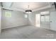 Spacious bedroom with carpet, a tray ceiling, modern lighting, and multiple windows and a mirror at 3832 Amalia Pl, Indian Land, SC 29707