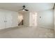Bedroom featuring carpet, three windows with blinds, a ceiling fan, and access to a hallway and bathroom at 3832 Amalia Pl, Indian Land, SC 29707
