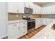 Close-up of a kitchen with stainless steel appliances, tile backsplash, granite countertop, and white cabinetry at 3832 Amalia Pl, Indian Land, SC 29707
