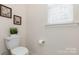 Bright powder room featuring a toilet, window, and decorative artwork at 4019 Channel Islands Way, Lancaster, SC 29720