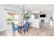 Modern dining room with stylish table, blue chairs, and view to outdoor pergola at 407 Goodloe Dr, Charlotte, NC 28262