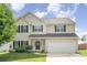 Two-story home with black shutters, fresh green lawn and a two car garage under a cloudy blue sky at 407 Goodloe Dr, Charlotte, NC 28262