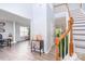 Sunlit foyer with wood floors leading to staircase and living room; plants and designer furnishings at 407 Goodloe Dr, Charlotte, NC 28262
