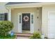 Home's front door with a wreath and matching sidelights, windchimes, and tidy landscaping at 407 Goodloe Dr, Charlotte, NC 28262