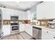 Well-lit kitchen with stainless steel appliances, mosaic tile backsplash and white cabinets at 407 Goodloe Dr, Charlotte, NC 28262