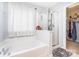Bright main bathroom featuring a soaking tub, glass enclosed shower and access to a walk-in closet at 407 Goodloe Dr, Charlotte, NC 28262