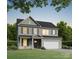 Charming two-story home with gray siding, white trim, shutters, well-manicured lawn and a two-car garage at 5120 Izzo Ln, Charlotte, NC 28214