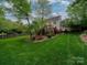 Well-manicured backyard featuring a spacious lawn, mature trees, and an inviting deck area at 5412 Crosshill Ct, Charlotte, NC 28277