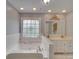 Bathroom featuring a large soaking tub, vanity with double sinks, and decorative window at 5412 Crosshill Ct, Charlotte, NC 28277