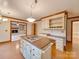 Kitchen island with cooktop and adjacent living room with fireplace and built-in shelving at 5412 Crosshill Ct, Charlotte, NC 28277
