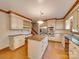 Spacious kitchen features a central island with cooktop, stainless steel appliances, and custom cabinetry at 5412 Crosshill Ct, Charlotte, NC 28277