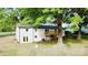 Lush backyard with mature trees and a wooden balcony that is attached to the home at 5520 Chestnut Dr, Hickory, NC 28602