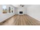 Bright living room with a white brick fireplace, ceiling fan, and luxury vinyl flooring at 5520 Chestnut Dr, Hickory, NC 28602