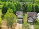 Aerial view of a two-story home with a two-car garage surrounded by lush greenery at 5524 Wyalong Dr, Charlotte, NC 28227
