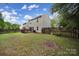 Fenced backyard featuring a wooden deck, grassy area, and mature trees offering privacy and space at 5524 Wyalong Dr, Charlotte, NC 28227