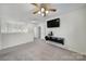 Bonus room featuring neutral walls, plush carpet, a ceiling fan, and mounted television set at 5524 Wyalong Dr, Charlotte, NC 28227