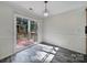 Bright dining area with chandelier, sliding door access to the outdoor deck, and stylish gray laminate flooring at 5524 Wyalong Dr, Charlotte, NC 28227