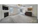 Open living room with a cozy fireplace, neutral carpet, natural light, and direct access to the deck at 5524 Wyalong Dr, Charlotte, NC 28227