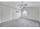 Spacious carpeted primary bedroom with ceiling fan, natural light, and TV mount for comfort at 5524 Wyalong Dr, Charlotte, NC 28227