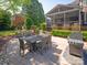 Backyard patio with dining table, grill, and seating in a lush landscaped outdoor space at 5809 Woodleigh Oaks Dr, Charlotte, NC 28226