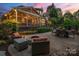 Inviting backyard patio area with a fire pit, comfortable seating, and an outdoor dining table with a grill at 5809 Woodleigh Oaks Dr, Charlotte, NC 28226