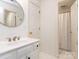 Clean bathroom with white sink vanity, round mirror, and walk-in shower at 5809 Woodleigh Oaks Dr, Charlotte, NC 28226