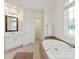 Bright bathroom with a soaking tub, a large window and double door access at 5809 Woodleigh Oaks Dr, Charlotte, NC 28226
