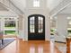 Bright foyer featuring double doors, wood floors, and views into the dining and living areas at 5809 Woodleigh Oaks Dr, Charlotte, NC 28226