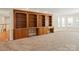 Spacious living room with large wooden built-in bookshelves and ample light at 5809 Woodleigh Oaks Dr, Charlotte, NC 28226