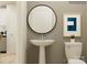 Modern half bathroom featuring a pedestal sink, round mirror, and contemporary decor at 671 Mile Creek Rd, Edgemoor, SC 29712