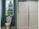 Modern bathroom featuring a toilet, glass-enclosed shower, and window offering natural light and style at 671 Mile Creek Rd, Edgemoor, SC 29712