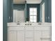 Bathroom with double vanity, sleek white countertops, and a large mirror providing a bright, open feel at 671 Mile Creek Rd, Edgemoor, SC 29712