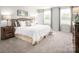 Serene main bedroom with neutral color palette, large windows, plush carpeting, and stylish furnishings at 69 Millstream Dr, China Grove, NC 28023