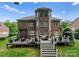 Expansive backyard view showing brick exterior, deck with seating, and well-maintained landscaping at 7005 Camrose Crossing Ln, Matthews, NC 28104