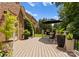 Beautiful outdoor deck area with an elegant brick home, flowering plants, and a green lawn and trees at 7005 Camrose Crossing Ln, Matthews, NC 28104