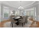 Formal dining room featuring a modern chandelier, large windows, and hardwood flooring at 7005 Camrose Crossing Ln, Matthews, NC 28104