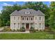 Stately stone and brick home with manicured landscaping and lush green lawn at 7005 Camrose Crossing Ln, Matthews, NC 28104