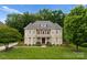 Beautiful stone and brick home with a manicured lawn and mature trees at 7005 Camrose Crossing Ln, Matthews, NC 28104