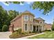 Charming stone and brick home showcasing a well-maintained yard and driveway at 7005 Camrose Crossing Ln, Matthews, NC 28104
