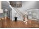 Elegant foyer with wood floors, curved staircase, wrought iron railings, and views into the living spaces at 7005 Camrose Crossing Ln, Matthews, NC 28104
