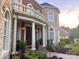 Covered front porch with elegant pillars and lush landscaping at 7005 Camrose Crossing Ln, Matthews, NC 28104