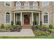Stunning stone and brick home featuring a columned front entrance, balcony, and landscaped front yard at 7005 Camrose Crossing Ln, Matthews, NC 28104
